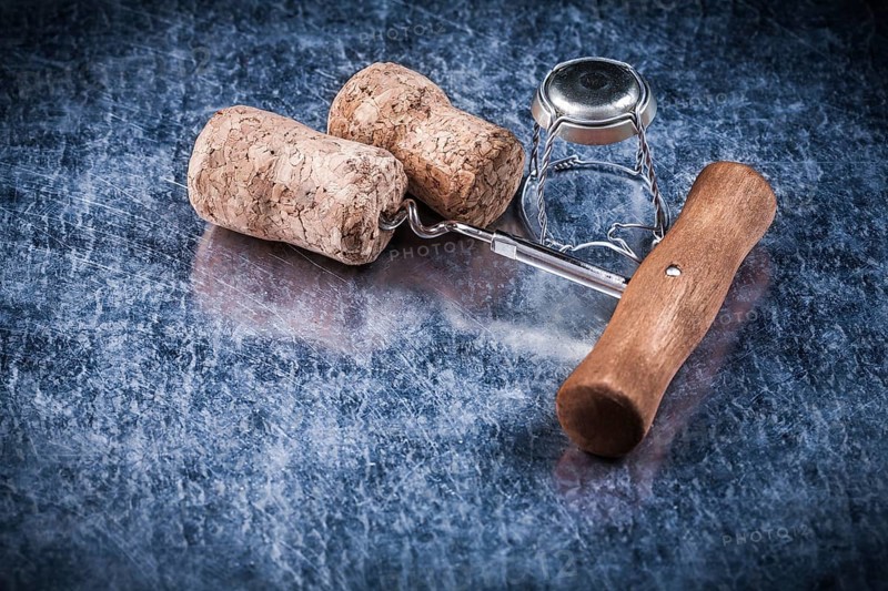 Champagne corks metal twisted wire corkscrew on metallic background