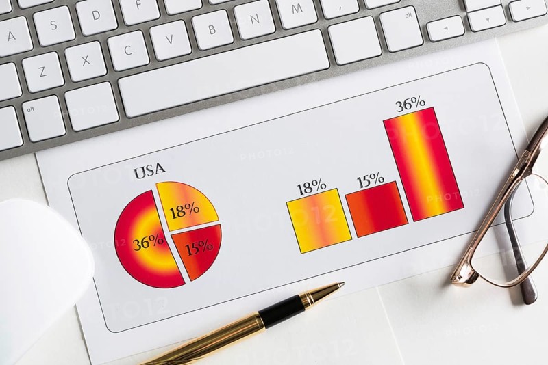 Business workplace with keyboard mouse and papers with graphs and diagrams