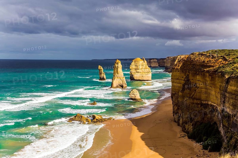 Magnificent morning light on the Pacific coast near Melbourne. Famous rocks Twelve Apostles in ocean waves surf. The concept of active and phototourism