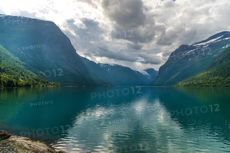 The Kjenndalsbreen is part of the Jostedalsbreen, one of the largest glaciers in Norway, and forms an impressive mountain landscape with a beautiful lake in Sande. The glacier Kjenndalsbreen with a lake in Norway is a beautiful place to travel to in summertime