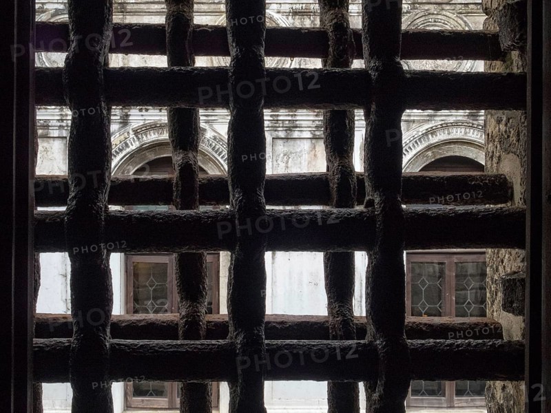 View trough iron grills of Circolo Artistico, the former prisons' building of the Doge's Palace, Venice, Veneto, Italy, Europe