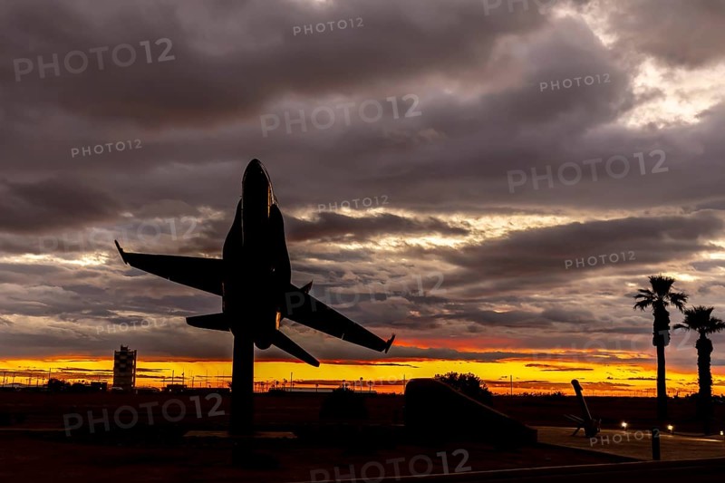 Dawn at Naval Air Field El Centro, CA: Sunlight paints vibrant hues across the sky, casting a mesmerizing rainbow over parked aircraft, creating a breathtaking spectacle