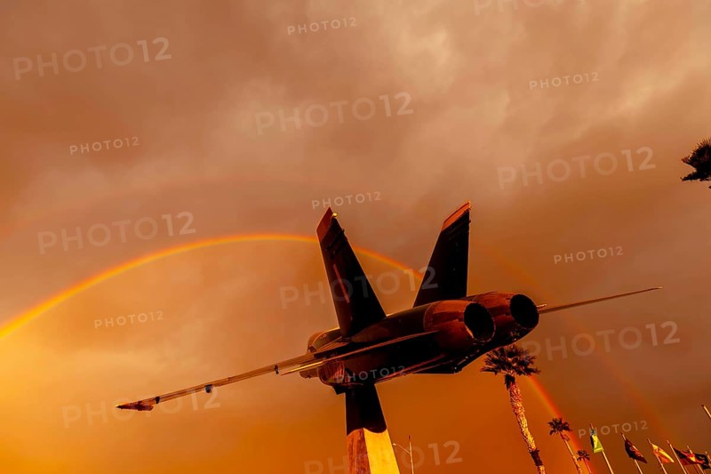 Dawn at Naval Air Field El Centro, CA: Sunlight paints vibrant hues across the sky, casting a mesmerizing rainbow over parked aircraft, creating a breathtaking spectacle