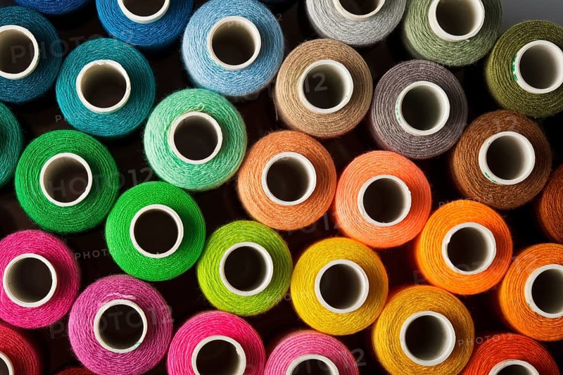 Sewing threads multicolored background closeup