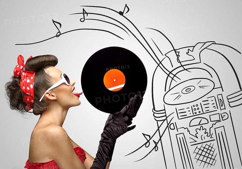 Vintage photo of a retro pinup girl licking retro records with her tongue against the sketchy background of a Wurlitzer jukebox