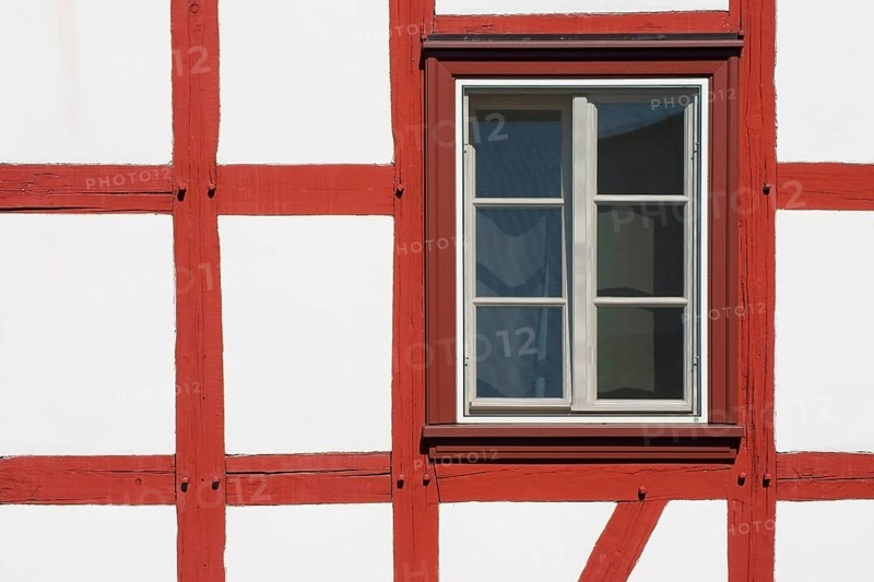 Close-up of the beam construction of a half-timbered house with windows