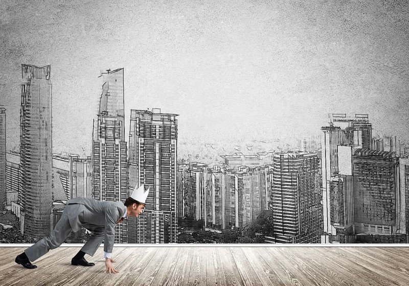 King businessman in elegant suit running and drawn cityscape silhouette at background