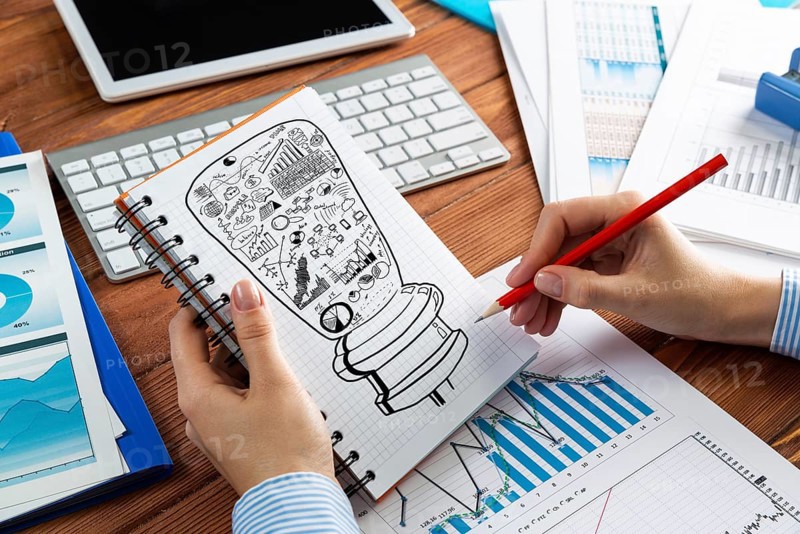 Close-up, woman draws business notes in her notebook. Business Innovation Concept
