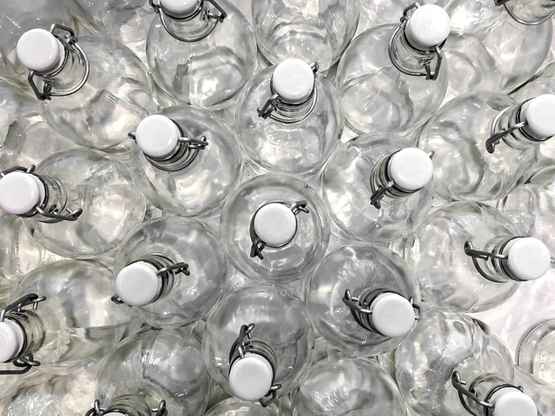 Transparent bottles seen from above. They can be filled with water, wine or other beverage. They are closed by a white plastic cap