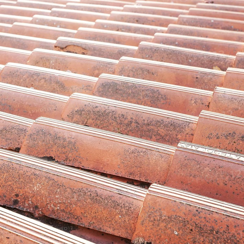 Old tiled roof. Close up of the red clay roof tiles. Background of old roof