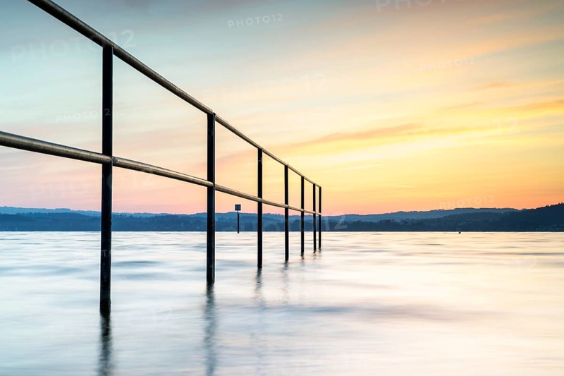 Railing in the lake at sunrise with gentle waves and peaceful sky, lido, Litzelstetten, Lake Constance, Baden-Württemberg, Germany, Europe