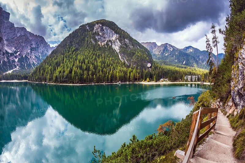 Magnificent Alpine lake Lago di Braies. Walking trail around the lake is fenced with wooden railings. The concept of environmental and hiking