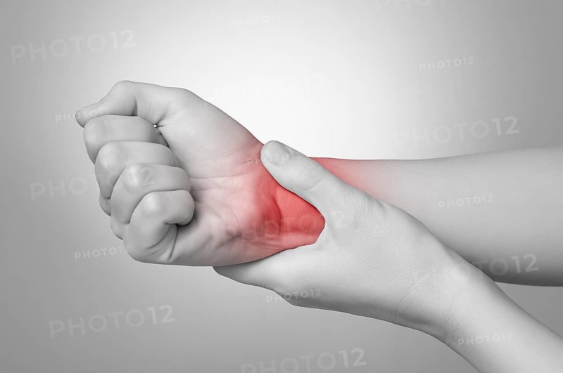 A young woman holding her painful wrist