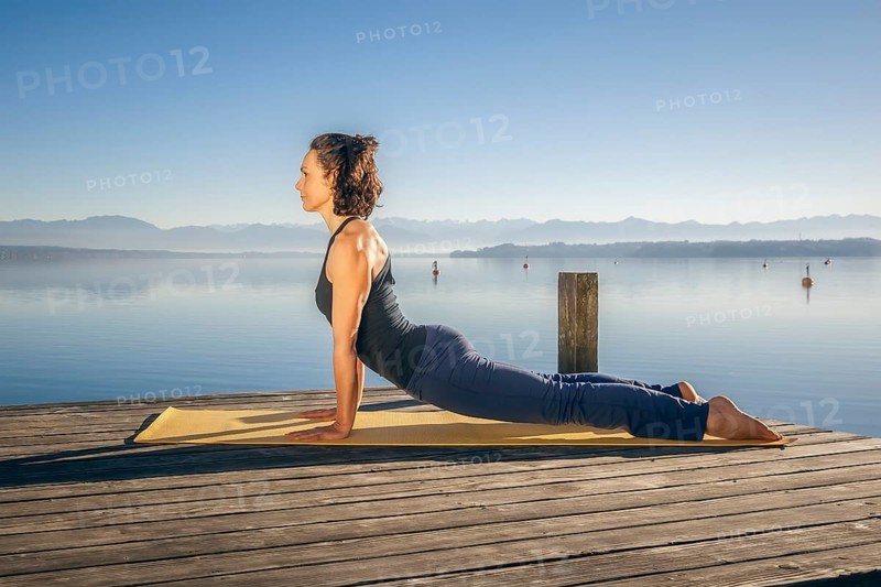 An image of a pretty woman doing yoga at the lake