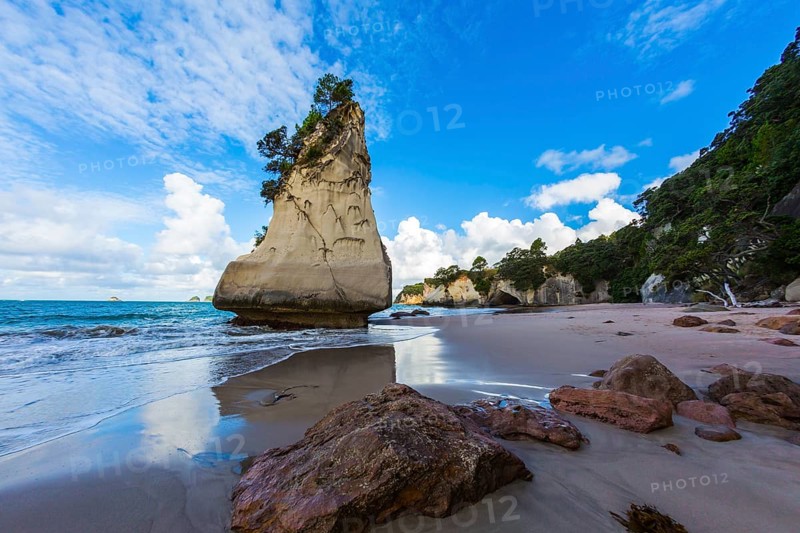 The North Island of New Zealand. Ocean low tide in Cathedral Cove at sunset. Huge boulders and picturesque rocks on a sandy beach. The concept of exotic, ecological and photo tourism