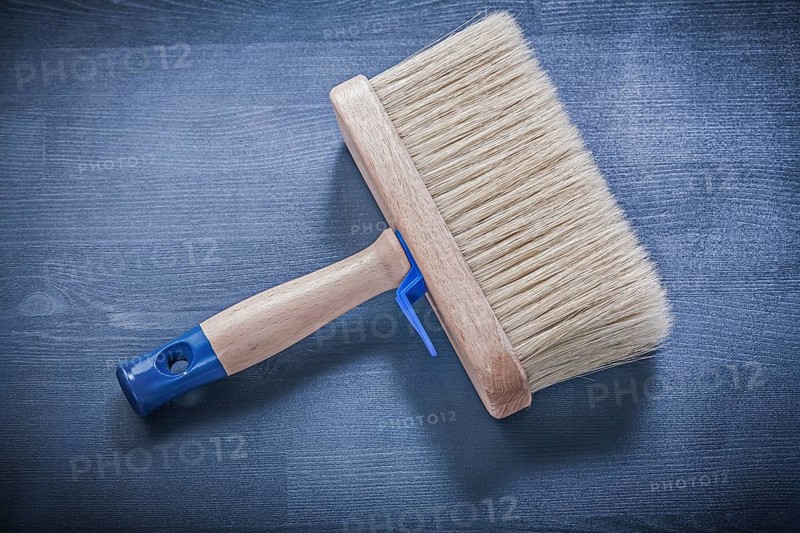 Wood board with paintbrush thick bristle construction concept