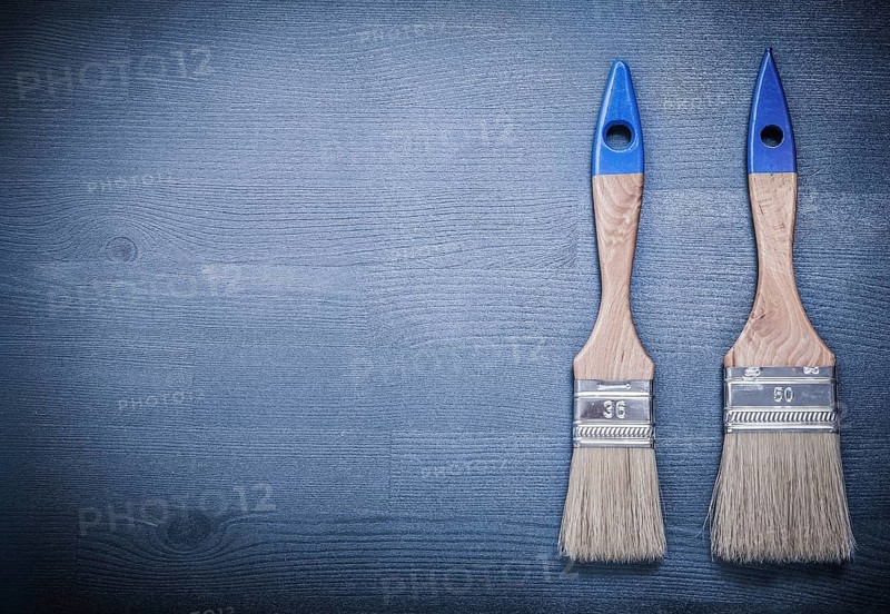 Paint brushes on wooden board construction concept
