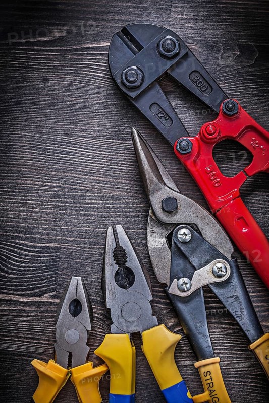 Metal wire steel cutter pliers on wood board construction concept