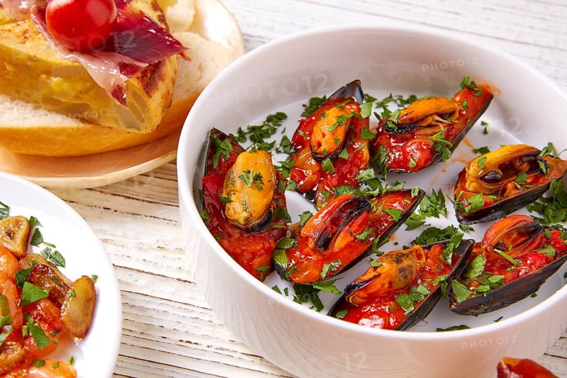Tapas mix and pinchos food from Spain recipes also pintxos on a white wood board