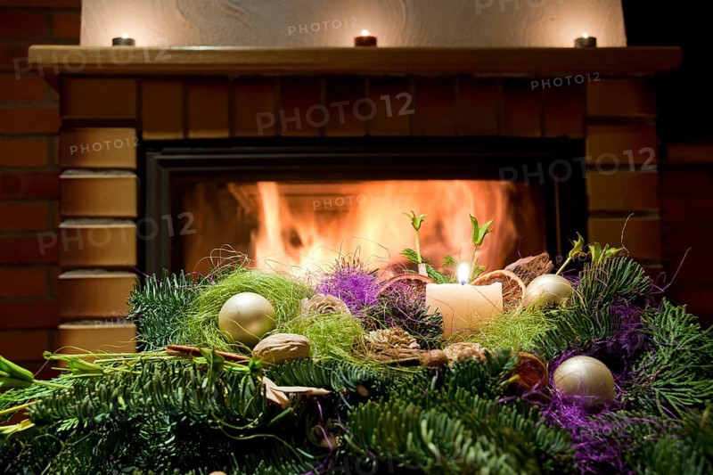 Christmas floral table decoration in front of the fireplace with candles