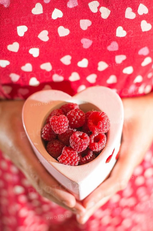 Woman in red dress holding a cup of raspberries