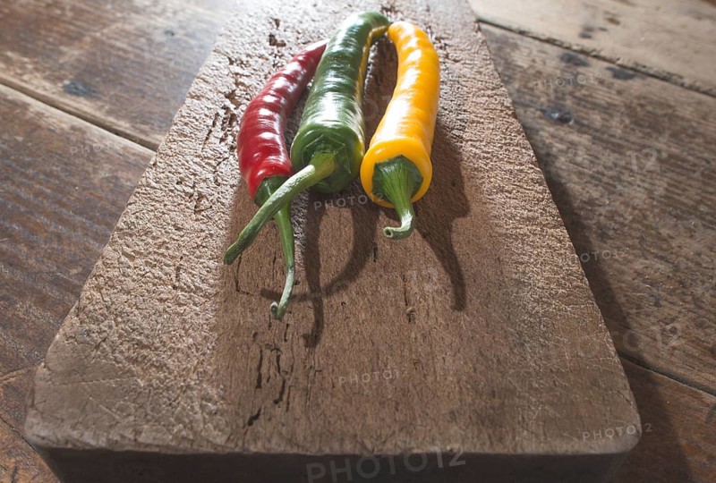 Hot peppers on wooden kitchen cutting board