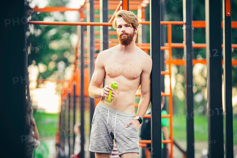 Thirst and health. Sportsman hold water bottle on stadium. Fit man with plastic flask outdoor. Stay hydrated and healthy. Sport and fitness