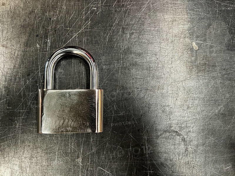 Metallic padlock on metal texture background