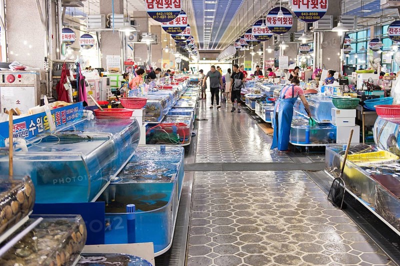 Indoor fish market in Yeosu, South Korea with living fish and people shopping, Yeosu, South Korea, Asia