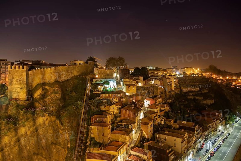 Night view of Porto funicular railway, house roofs with illumination