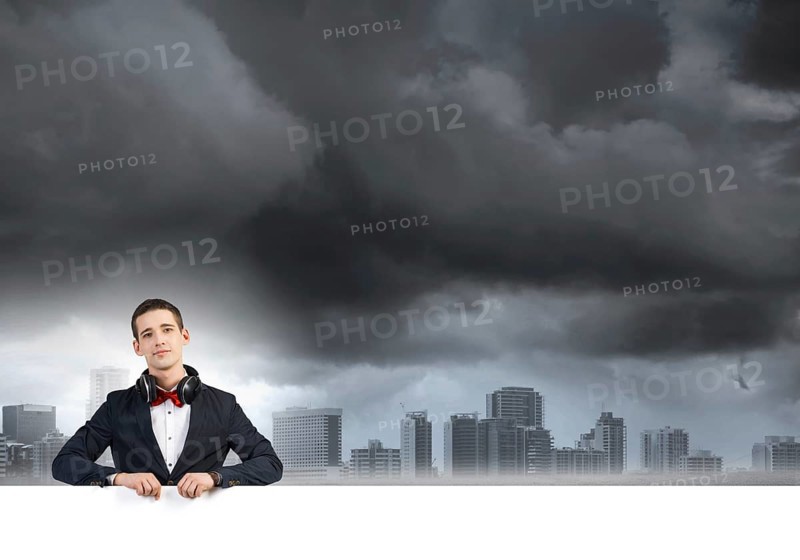 Handsome guy wearing headphones and holding white blank banner