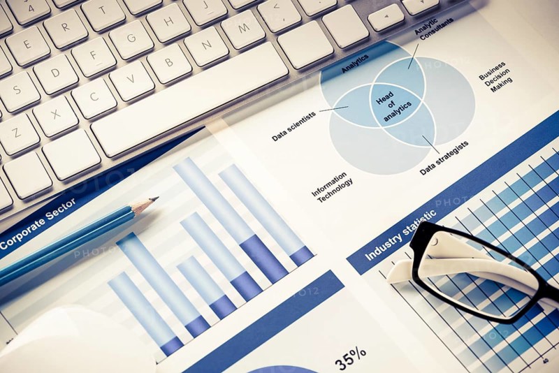 Business workplace with keyboard mouse and papers with graphs and diagrams