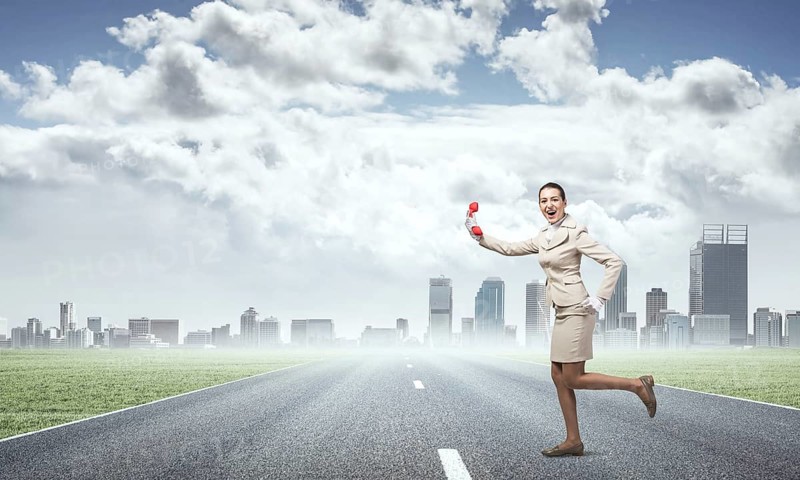 Woman running outdoor with vintage red phone. Expressive secretary with telephone on background downtown. Hotline telemarketing and communication. Professional business assistance and support