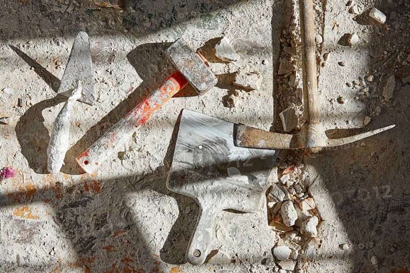 Mason tools on debris background in house improvement construction