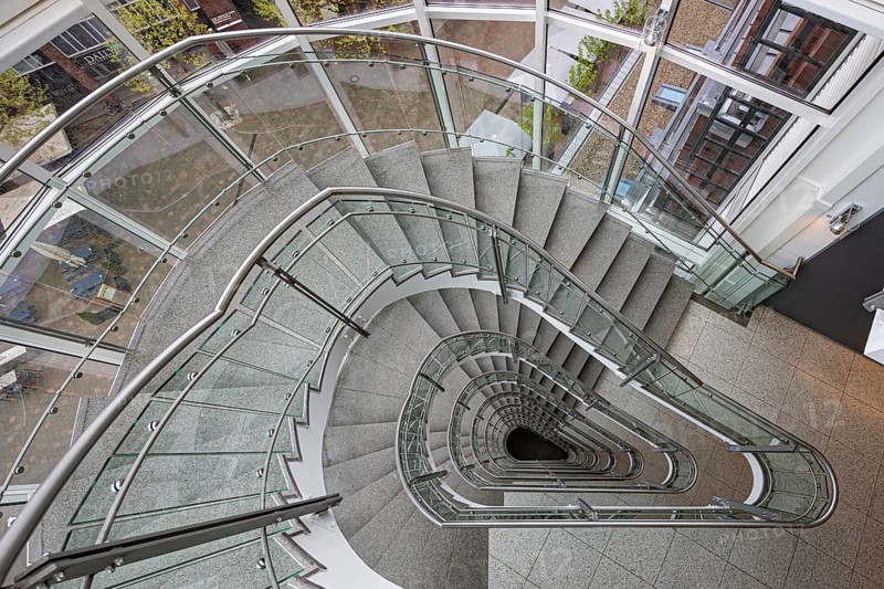 A modern spiral staircase with glass railings and a triangular shape in a bright room, Free and Hanseatic City of Hamburg, Germany, Europe