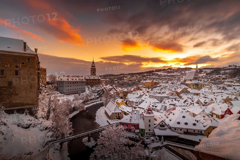 Winter view of Cesky Krumlov, picturesque houses under the castle with snow-covered roofs. Narrow streets and the Vltava river. Travel and Holiday in Europe. Christmas time. UNESCO World Heritage. Czech Republic