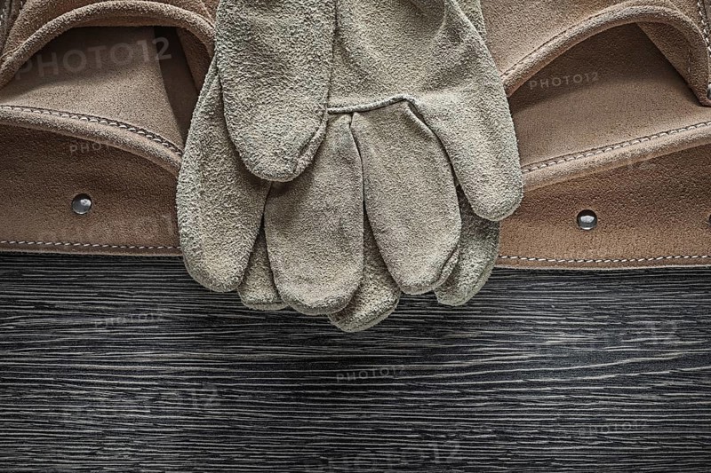 Tool belt safety gloves on wooden board