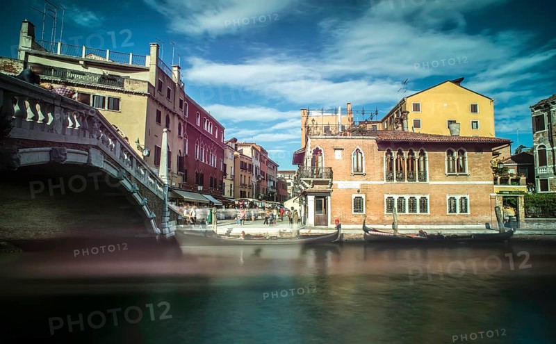Ancient buildings and boats in the channel in Venice