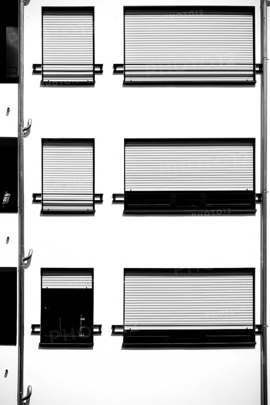 The modern façade of a modern residential building with a metal window with metal blinds