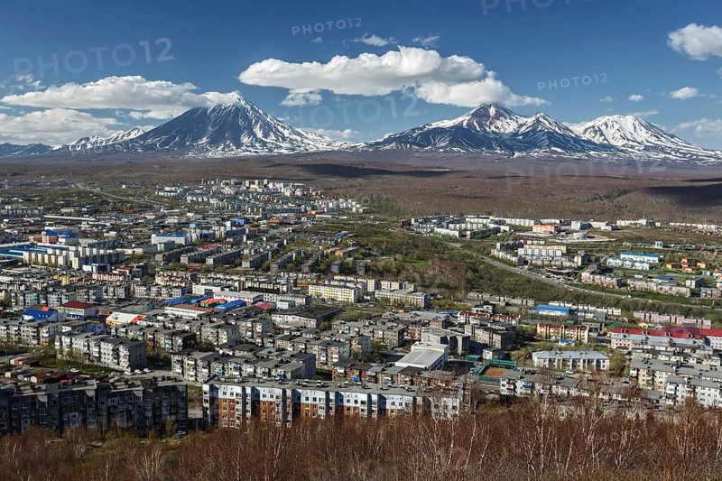 Panoramic view of the city Petropavlovsk-Kamchatsky and volcanoes: Koryaksky Volcano, Avacha Volcano, Kozelsky Volcano. Russian Far East, Kamchatka Peninsula