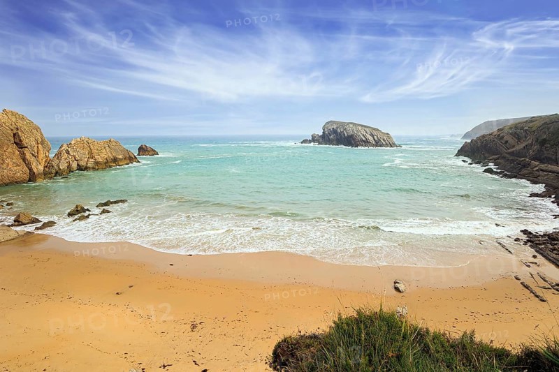 Playa de la Arnia beach. Amazing geological formations amaze tourists. Sea waves break on the coastal rocks. Snow-white sea foam glistens in the autumn sun. Cantabria, Spain, Europe
