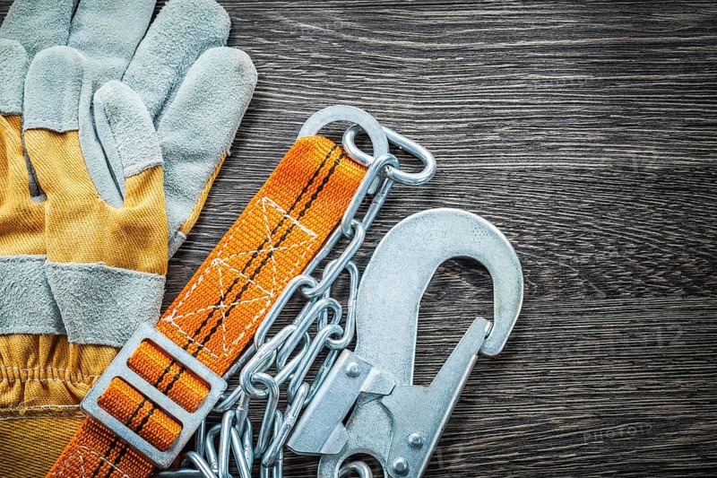 Construction gloves safety strap on wooden board