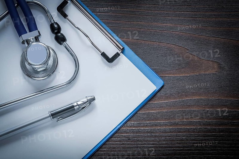 Clip board pen and stethoscope tablet on vintage wooden background medicine concept