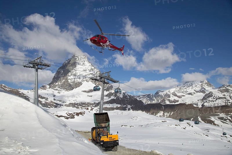 Zermatt, Switzerland, April 13, 2017: A helicopter loading concrete at a construction site in the Swiss mountains, Europe