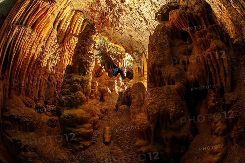 Colossal system of underground caves in Slovenia. Postojna Cave. Fantastically lit underground palaces with stalactites and stalagmites. Limestone plateau