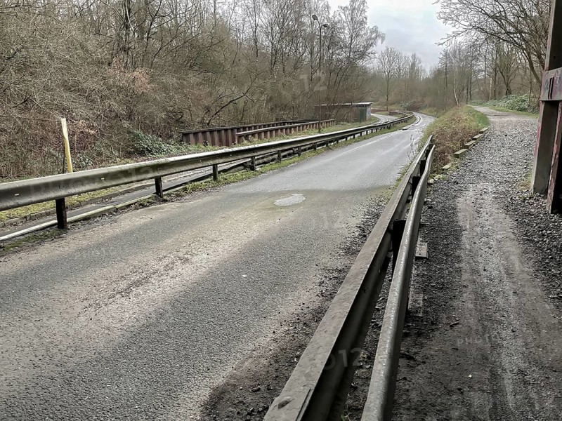 Unused industrial road in poor condition in the rain