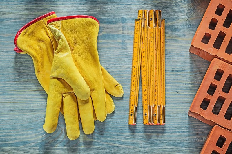 Leather safety gloves red bricks wooden meter on wood board bricklaying concept