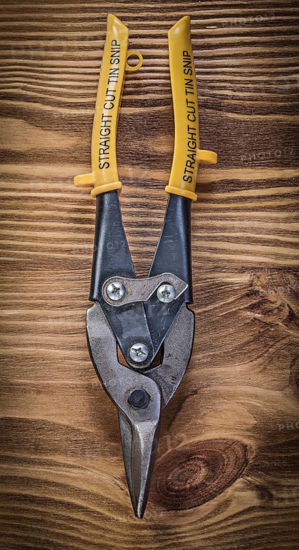 Sharp metal steel cutter on vintage wooden board construction concept