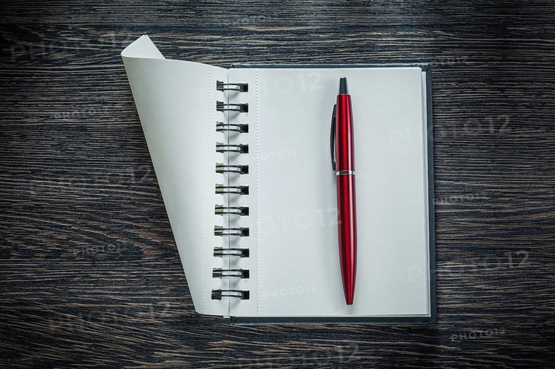 Spiral blank notebook ballpoint pen on vintage wooden board