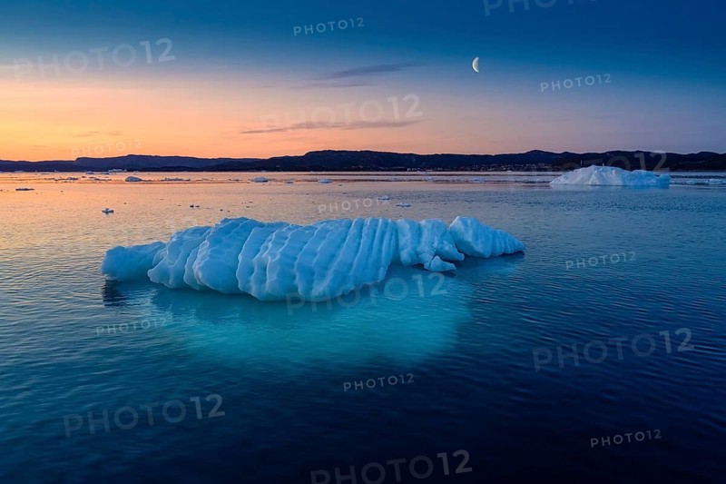 Floating glaciers in the rays of the setting sun at polar night with Moon